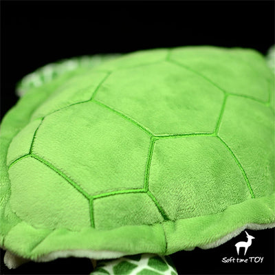 Dans l'Océan d'Animalia, une peluche réaliste de la Tortue Chelonia mydas nage avec tendresse.
